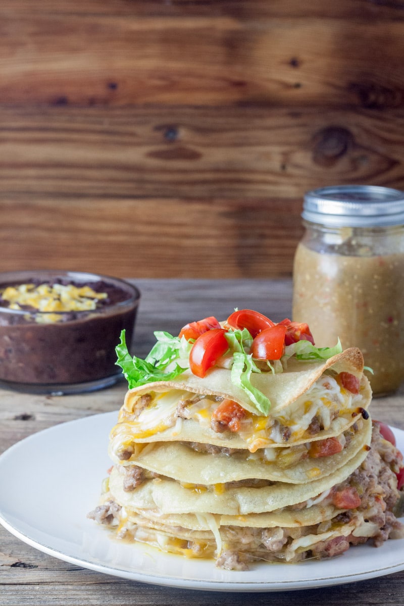 Tortillas stacked on top of each other with layers of beef and melted cheese in between.