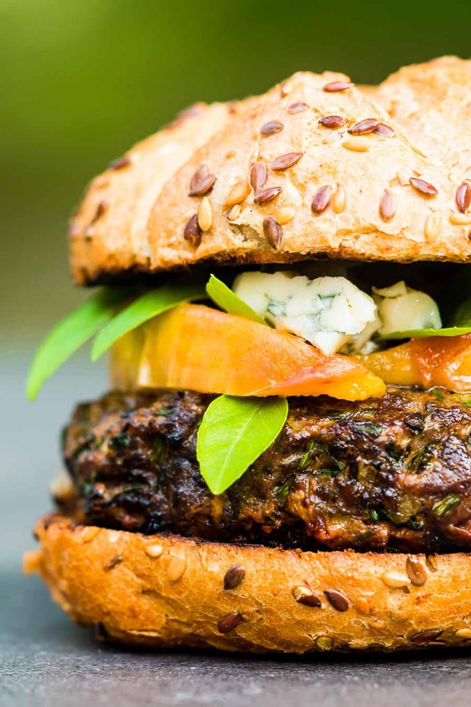 Closeup of venison recipe - Venison burger with peaches and blue cheese showing under towering bun 