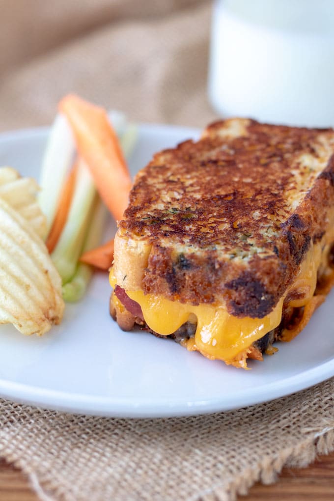 Cheese dripping out of grilled sandwich made with cheesy bread