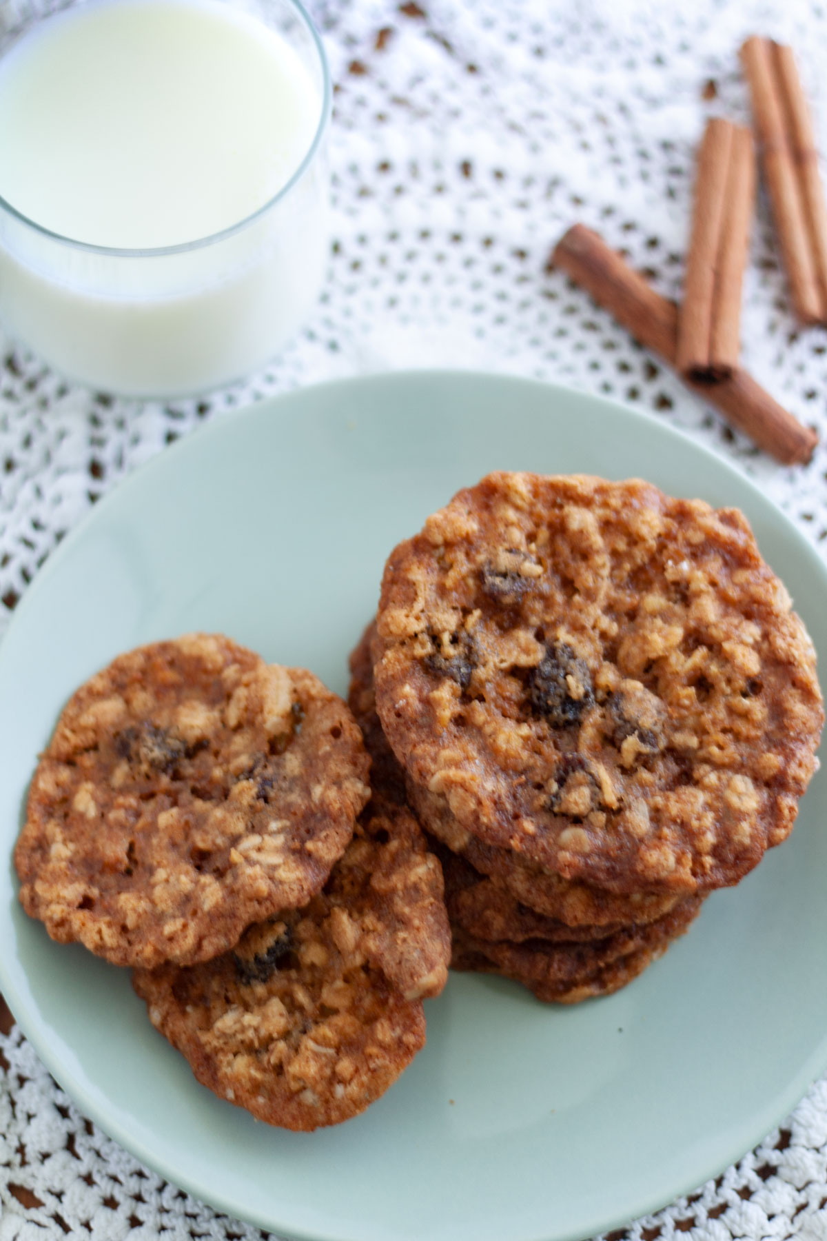 Pile of crispy oatmeal raisin cookies on lace doily.