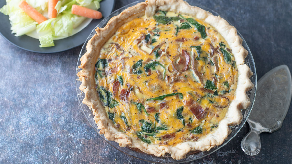 Whole quiche on black background.