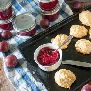 low sugar plum jam in white bowl with biscuits