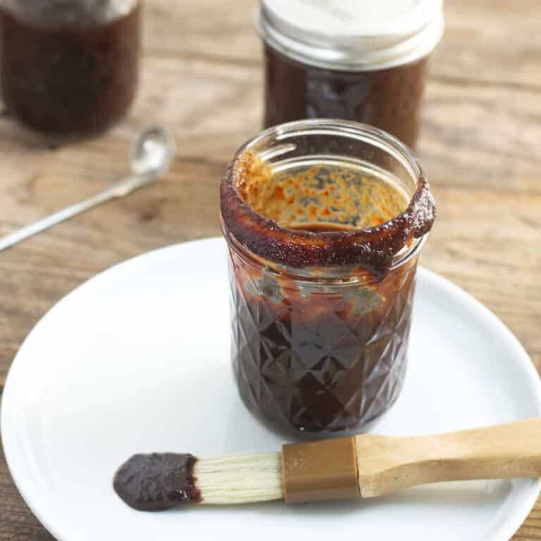 cherry bbq sauce in jar with brush on white plate