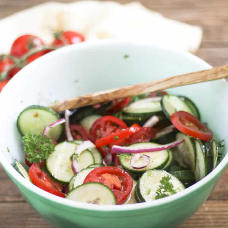 colorful cucumber and tomato salad in green bowl