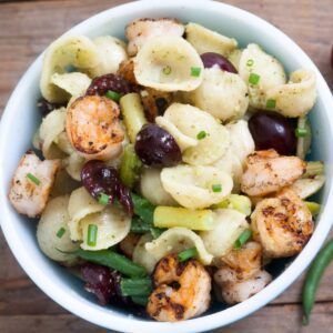 Pasta salad with grilled shrimp, fresh cherries and greens.