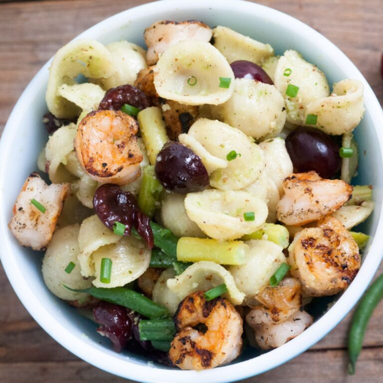 Pasta salad with grilled shrimp, fresh cherries and greens.