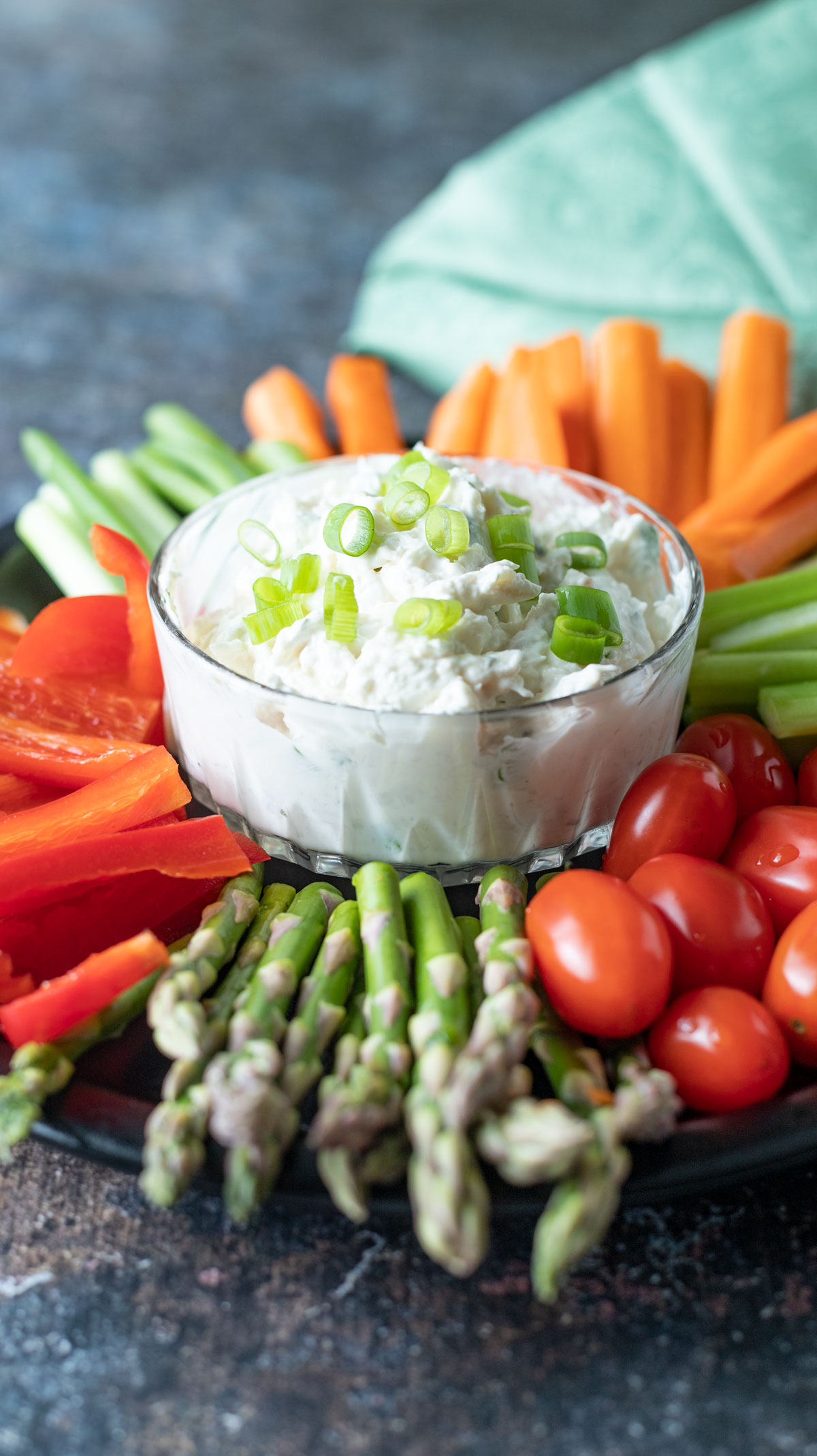 Shrimp and crab dip in a bowl surrounded by sliced veggies.
