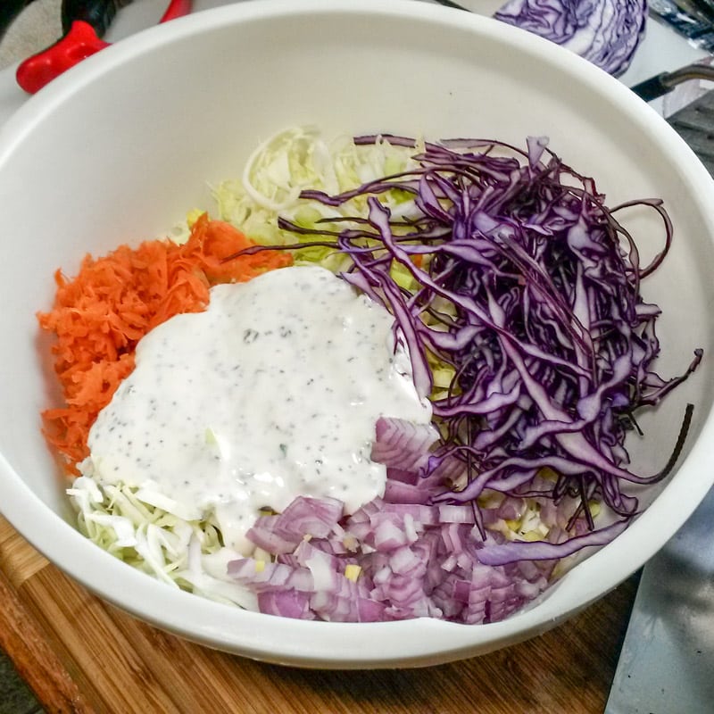 Dressing added to the coleslaw mix.