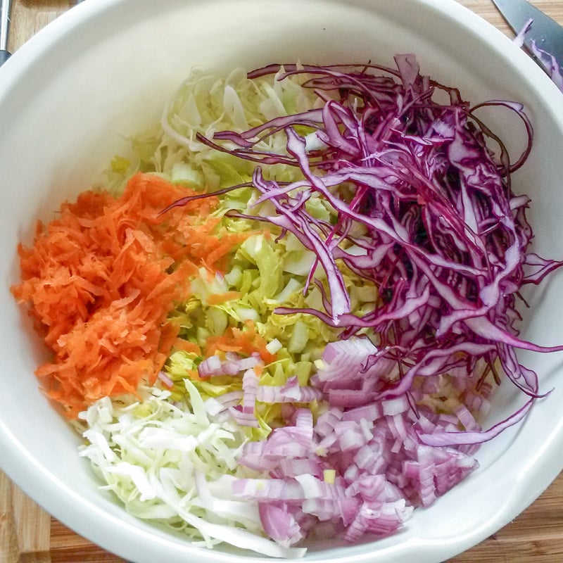 Cut cabbage and vegetables in mixing bowl.