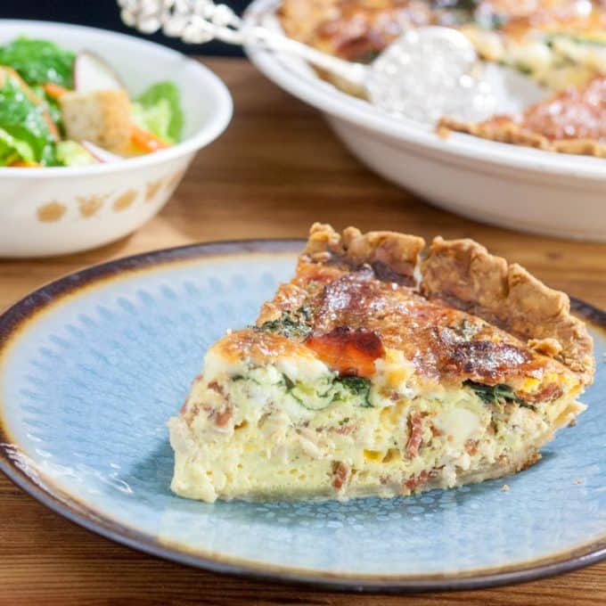 slice of chicken bacon quiche on blue plate