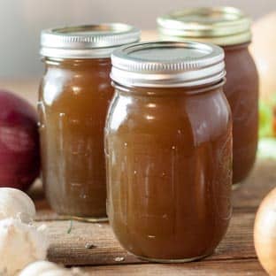 vegetable stock in pint jars on wood board