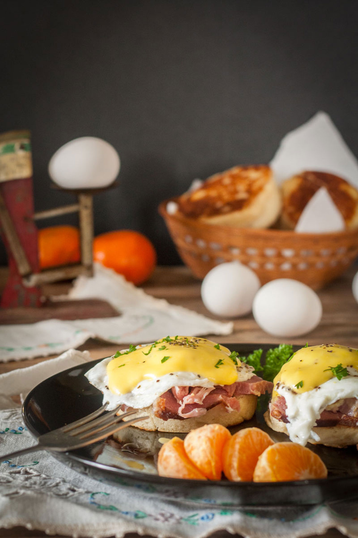 eggs benedict on black plate with parsley garnish Eggs benedict on black plate with parsley garnish