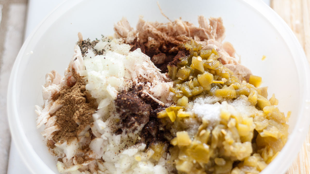 Chicken mixed with the other ingredients in a large bowl.