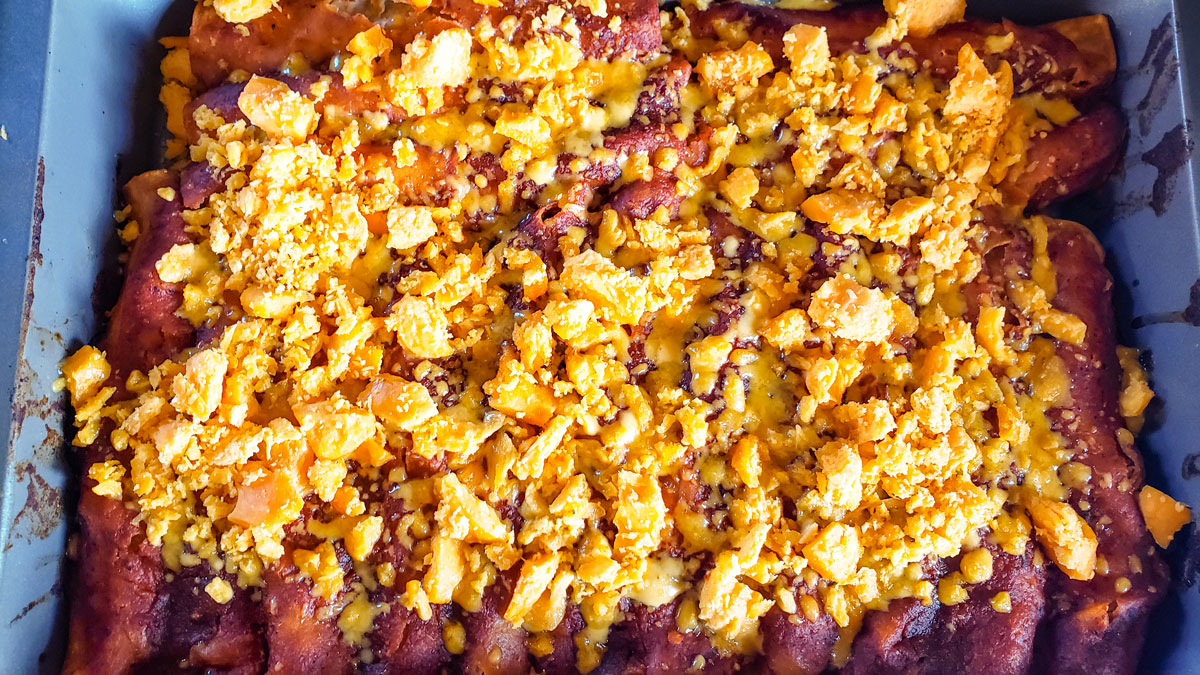 Enchilada casserole topped with cheese.
