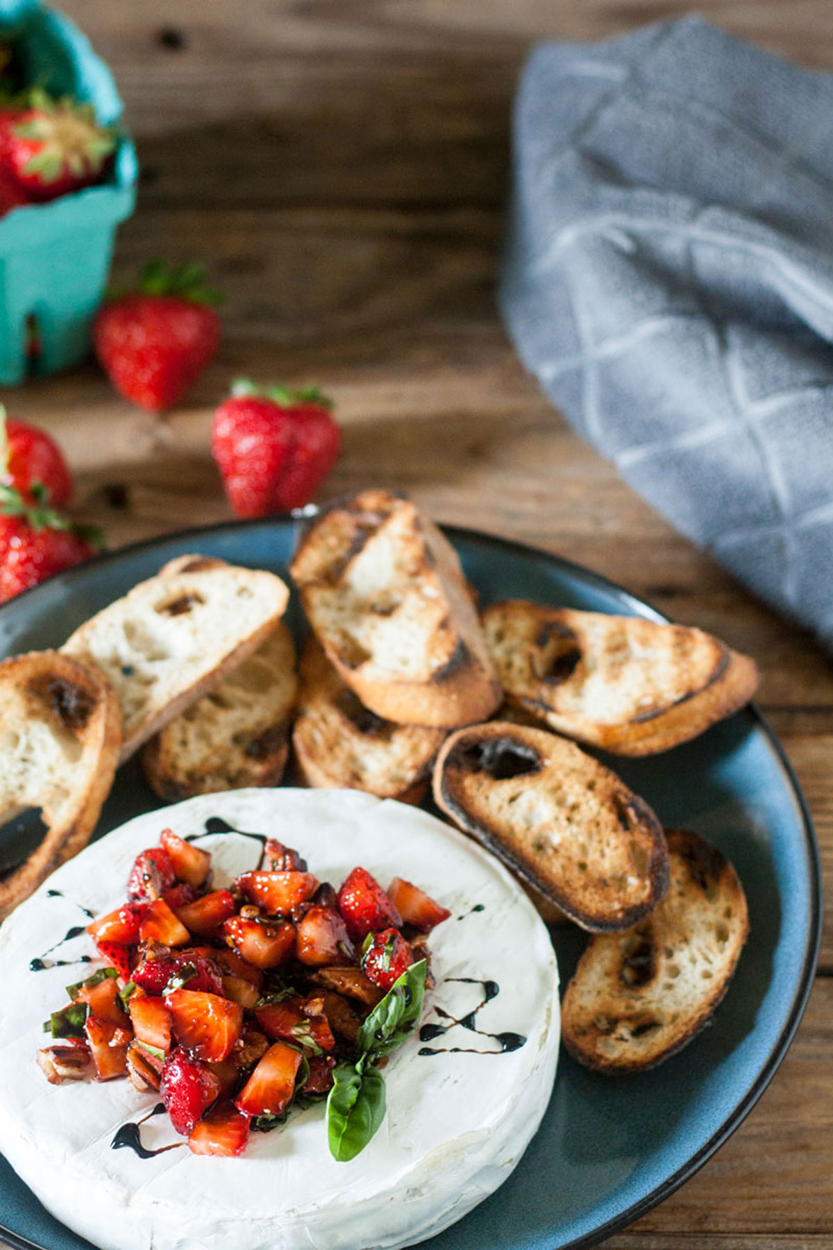 Brie toped with strawberries and drizzled with balsamic vinegar.