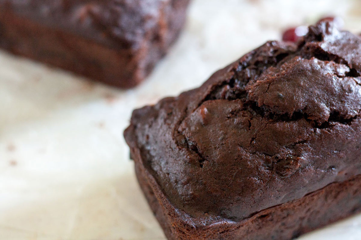 Chocolate Banana Bread with fresh cherries and nuts on white background with cherries