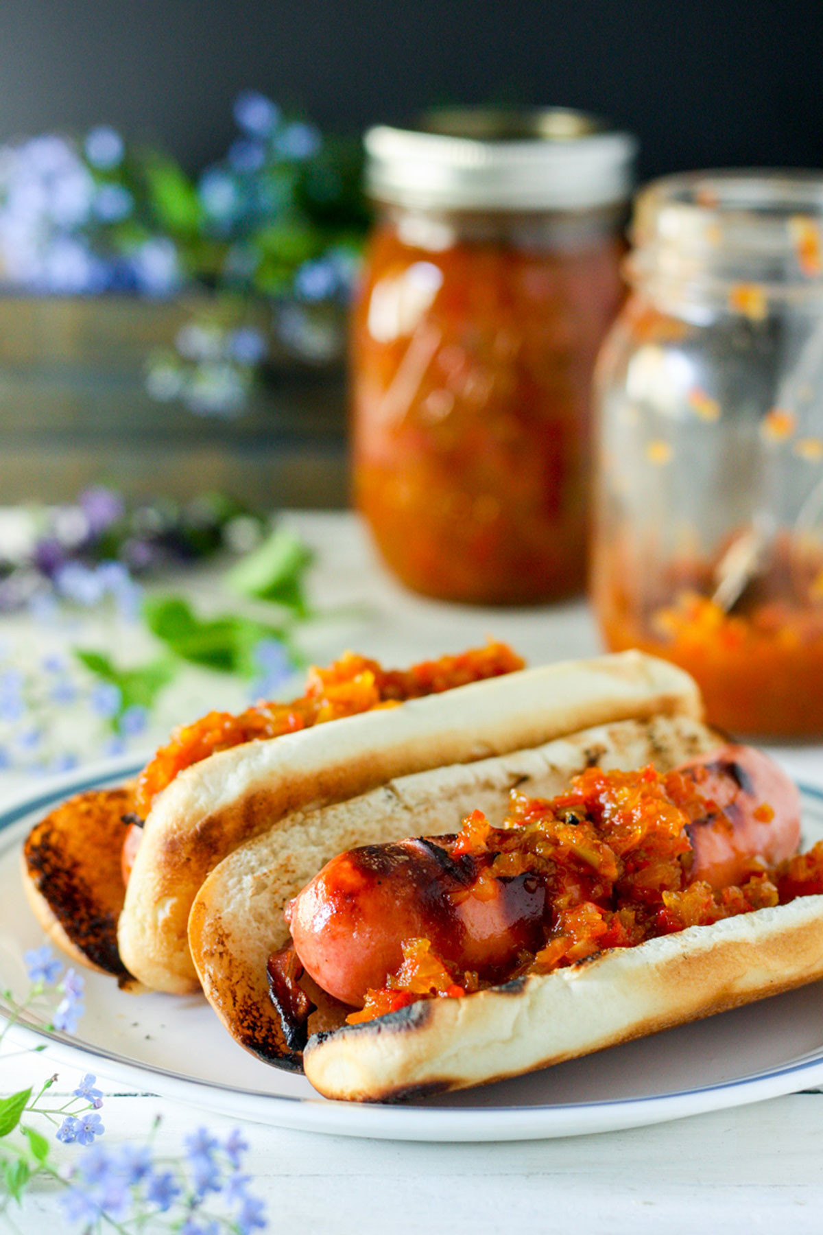 2 pop open hot dogs on buns topped with pepper relish Two pop open hot dogs on buns topped with pepper relish