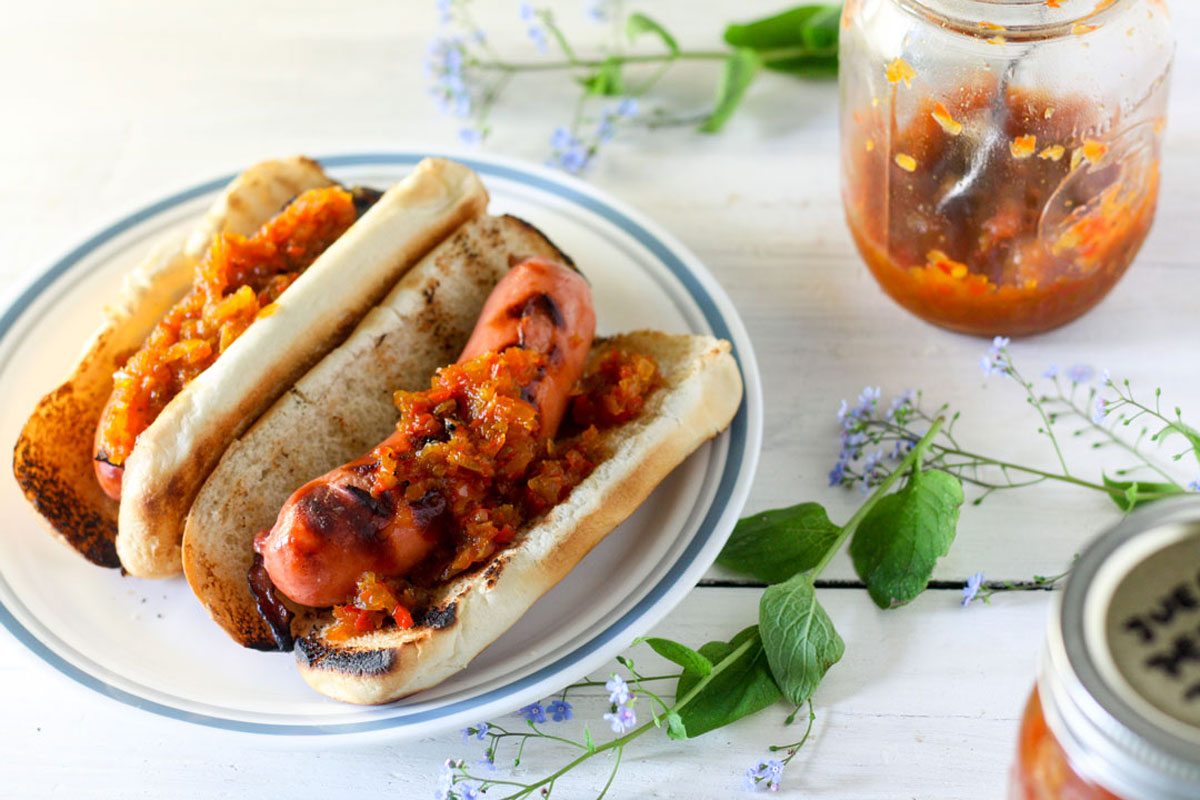2 hot dogs topped with relish Two hot dogs topped with relish.