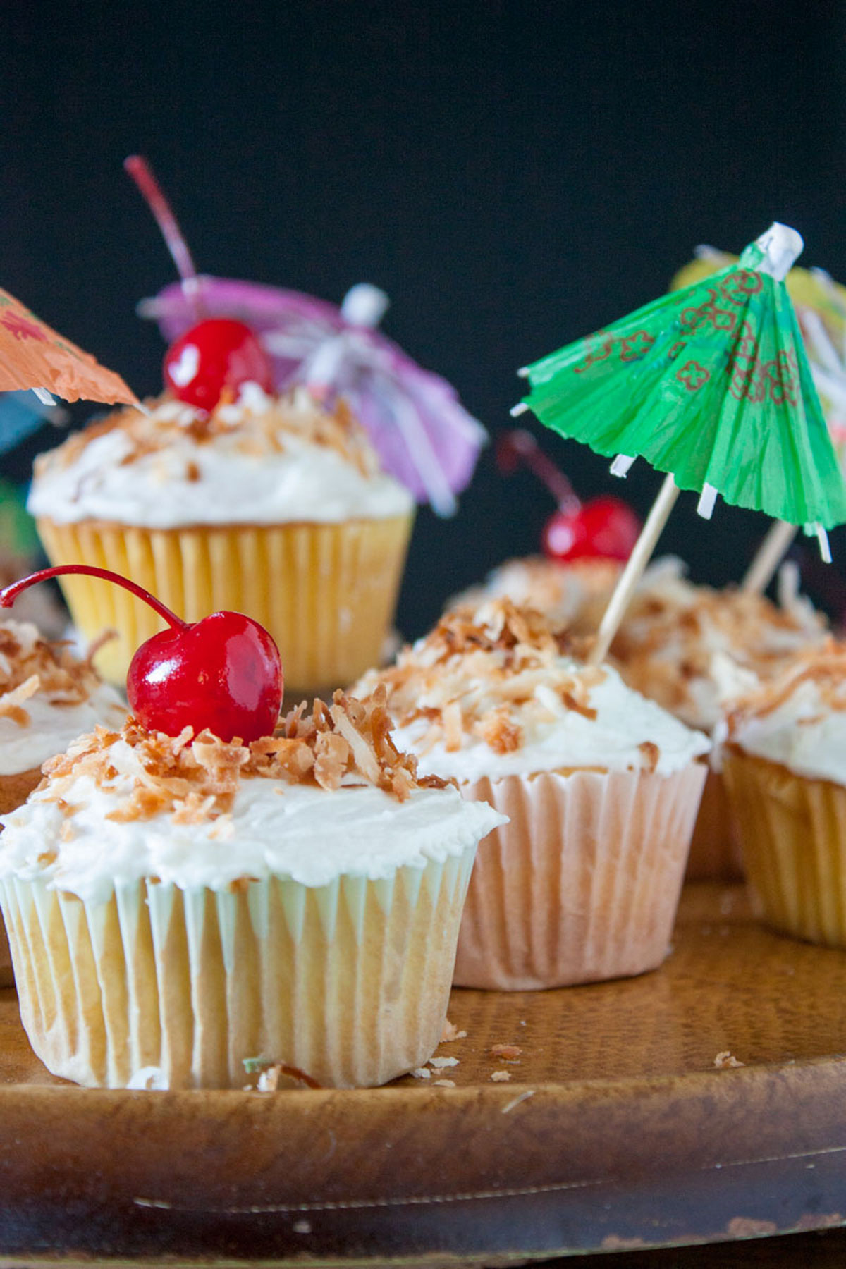 Pina colada cupcakes stacked on a pedestal cake plate.