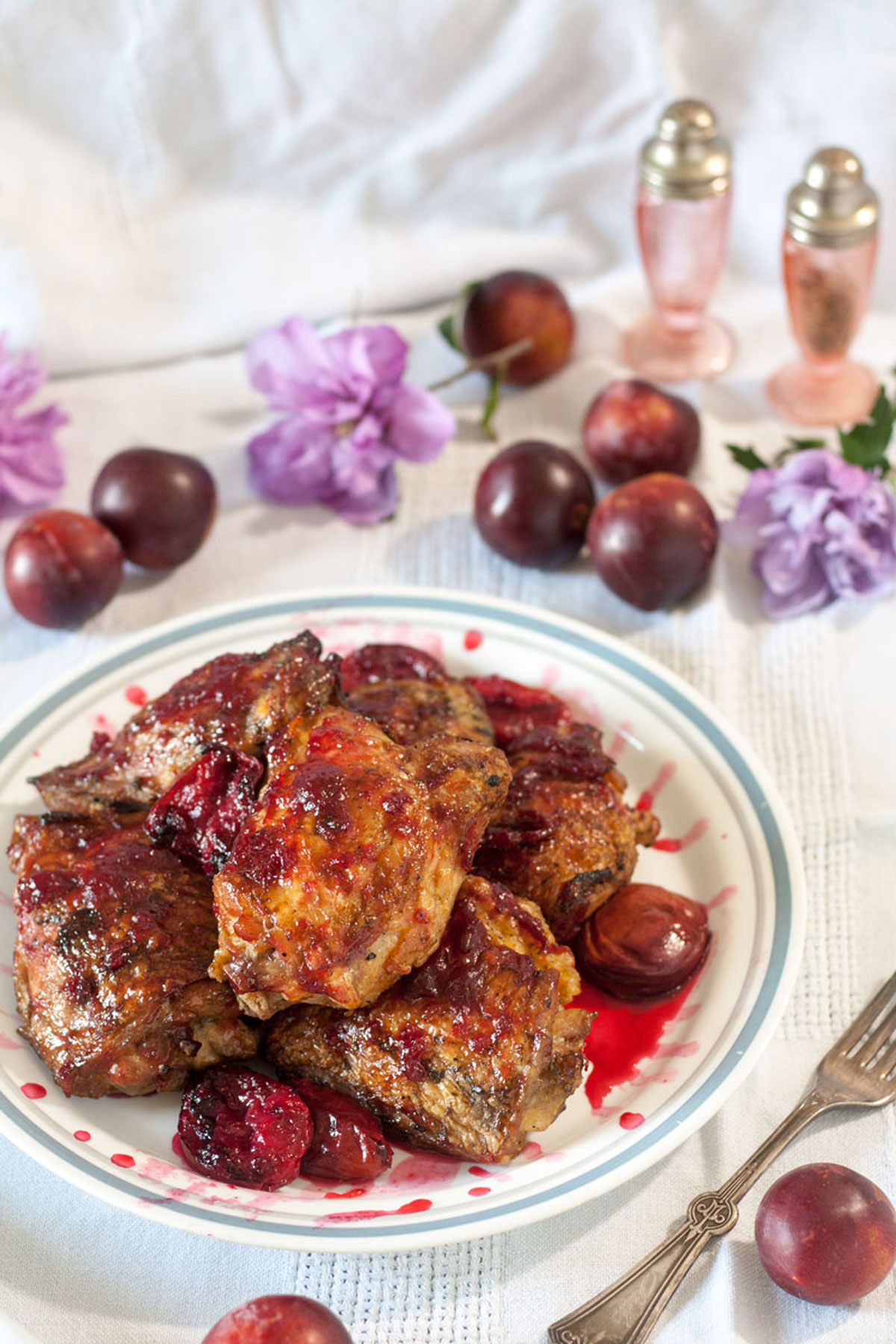 Chicken with Plum Sauce and Grilled Plums on white plate with blue border