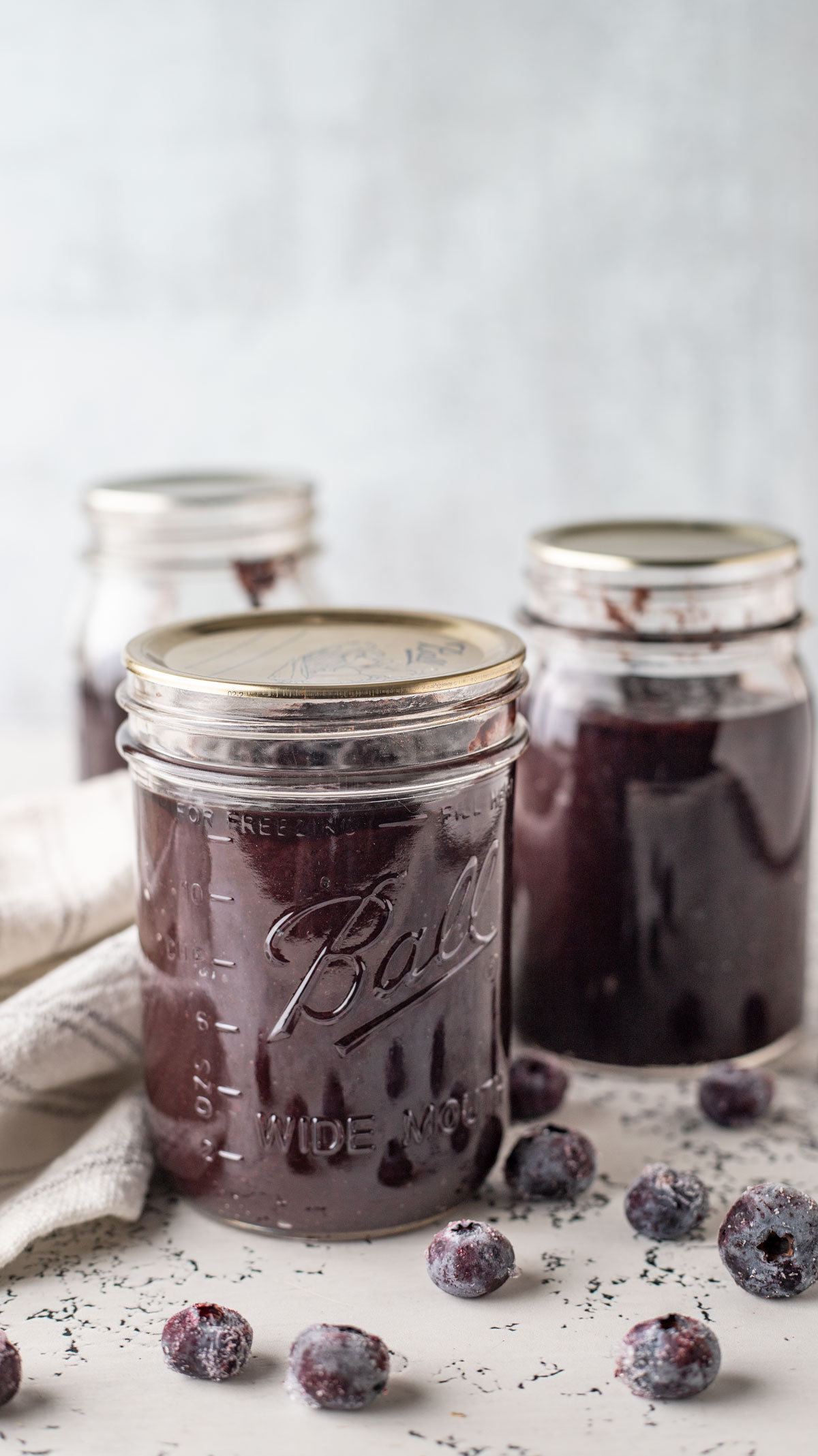 Jars of blueberry bbq sauce with fresh blueberries.