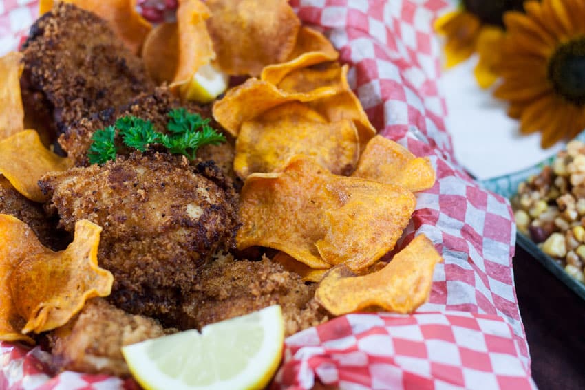 Basket of fish and chips with lemon wedge.