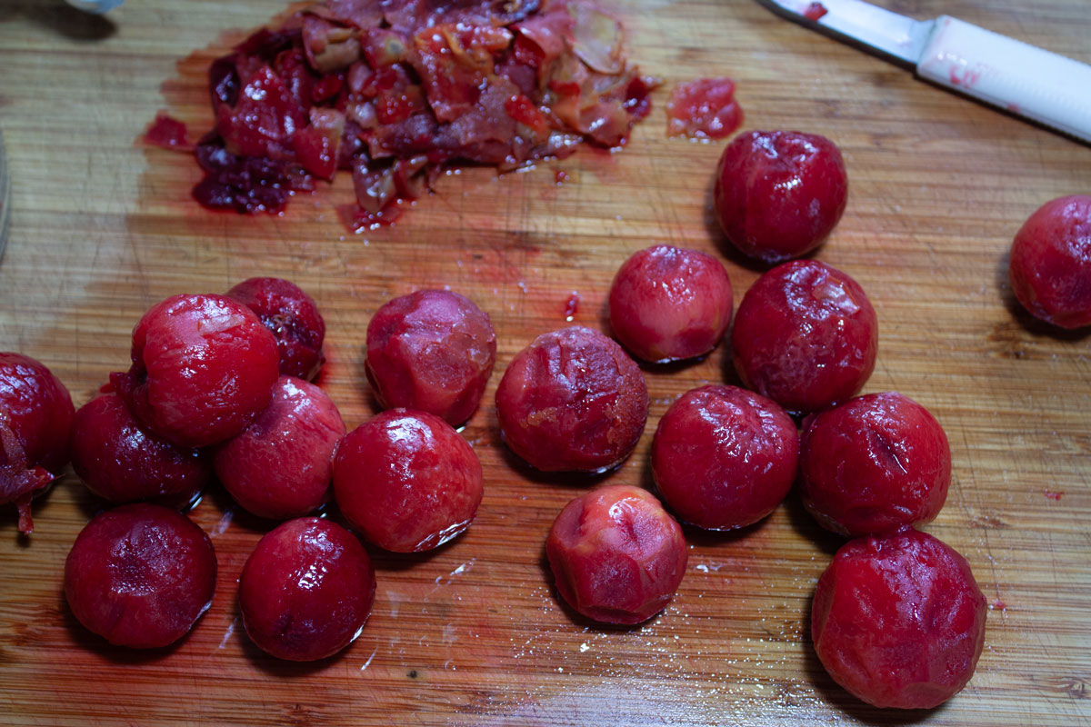 Plums on a cutting board after peeling.