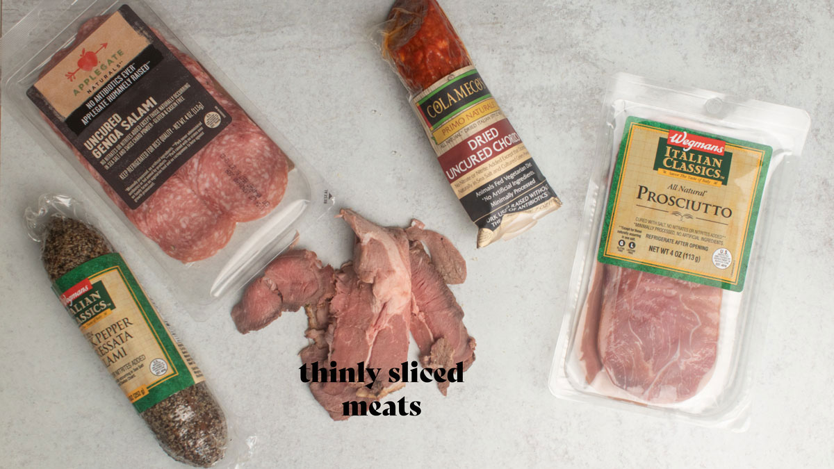 Assorted meats on a white board.