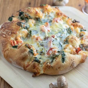 crispy, browned lobster pizza on wooden peel