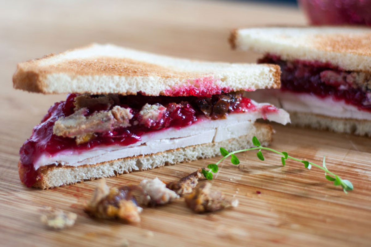 Sliced turkey sandwich on wooden board