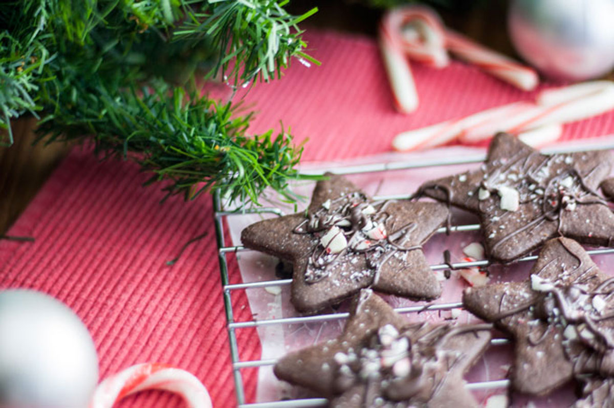 Chocolate and pepper cookie stars on a wire cooling rack.