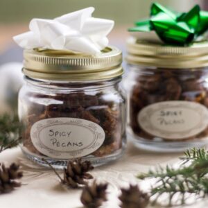 Spicy nuts in a decorative jar with a label and bow on top for gifting.