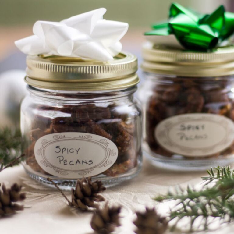 Spicy nuts in a decorative jar with a label and bow on top for gifting.