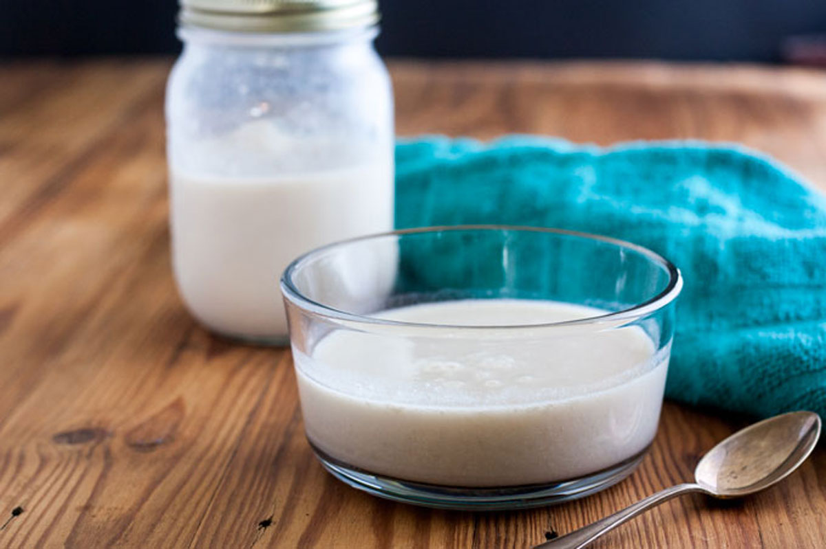 Evaporated milk substitute in clear bowl with green towel in background