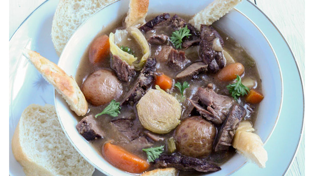 Venison neck roast stew in a white bowl.