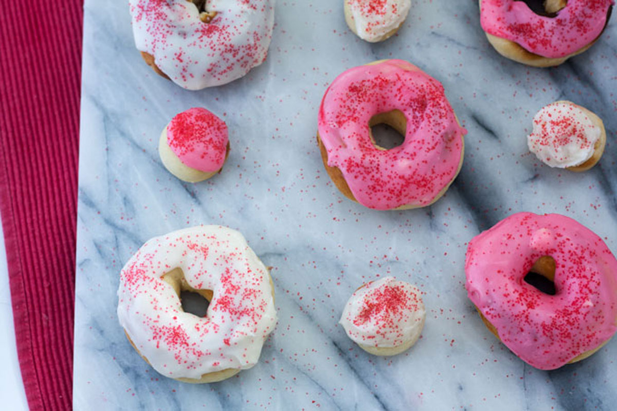 Pink frosted doughnut with cup of tea in tea cup