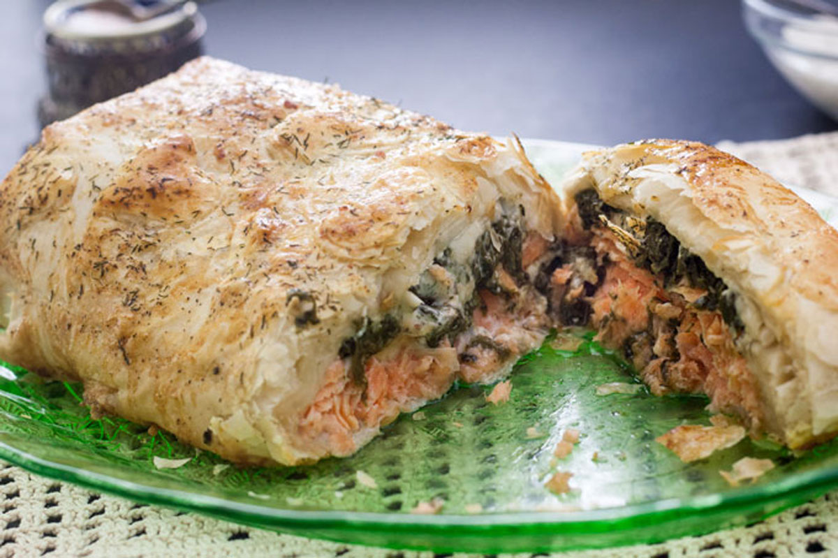Salmon wellington cut in half to reveal the salmon and spinach filling inside