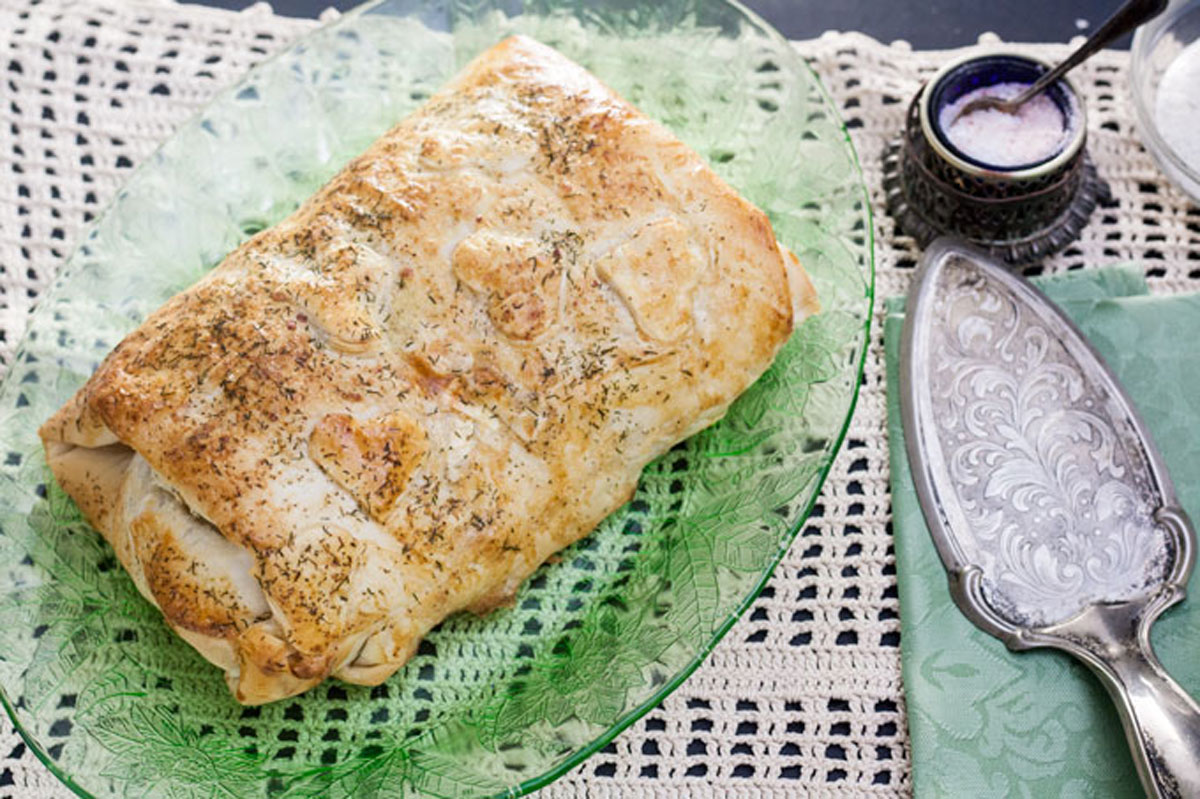 Whole salmon en croute on green antique platter
