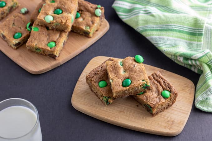 Pile of cookie bars on a wooden cutting board.