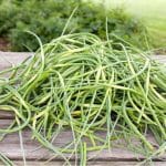 pile of garlic scapes on wooden table