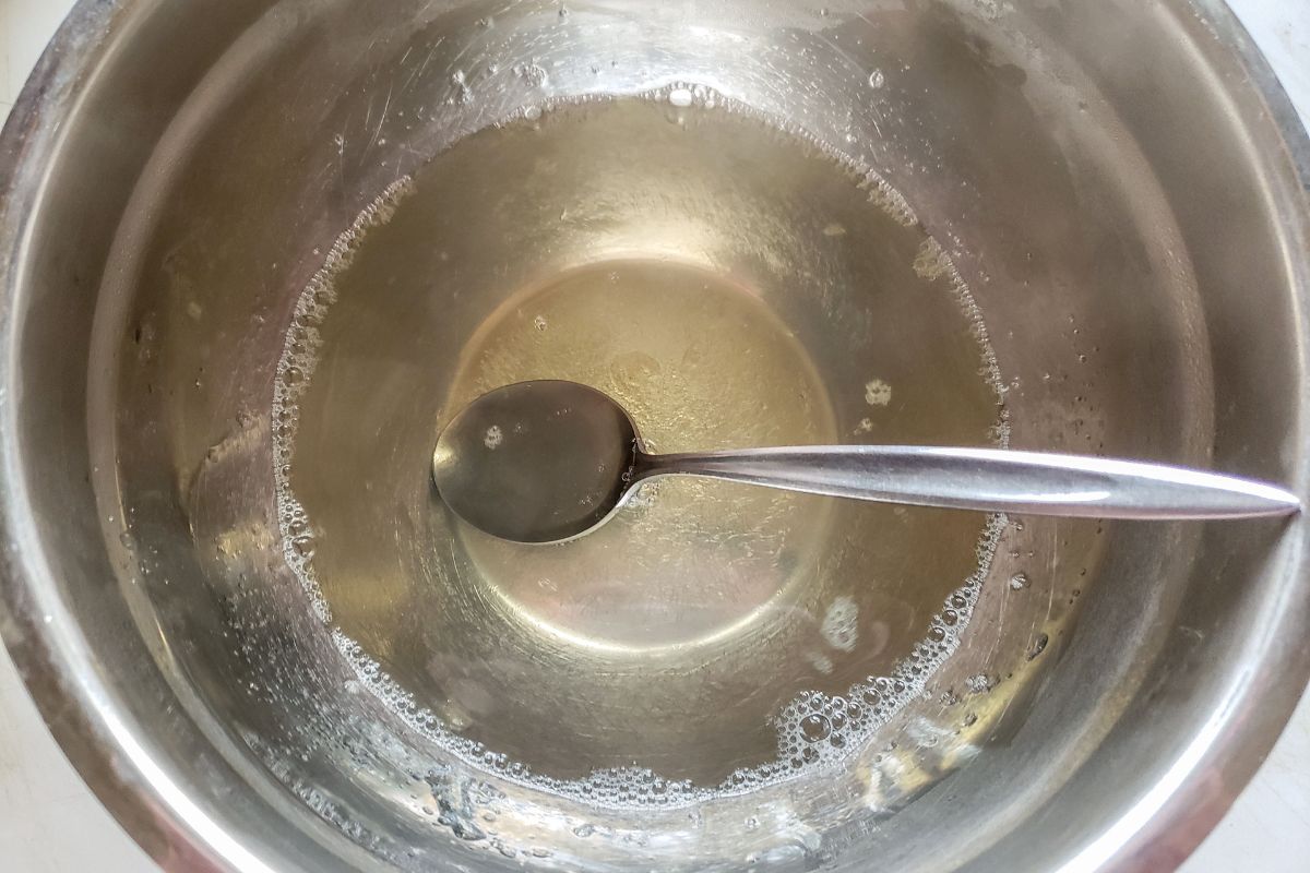 Clear gelatin mixed up in a metal bowl.