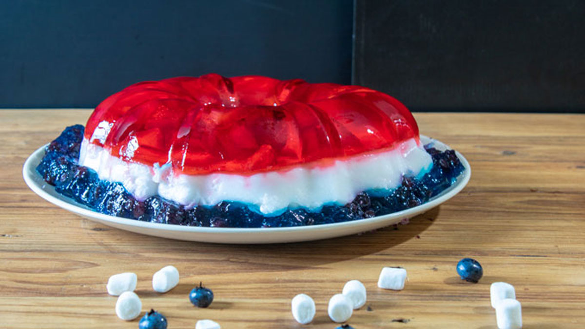 Side shot of jello salad on wooden board.