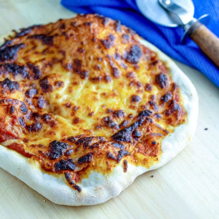 Sourdough pizza crust with browned edges and cheese.