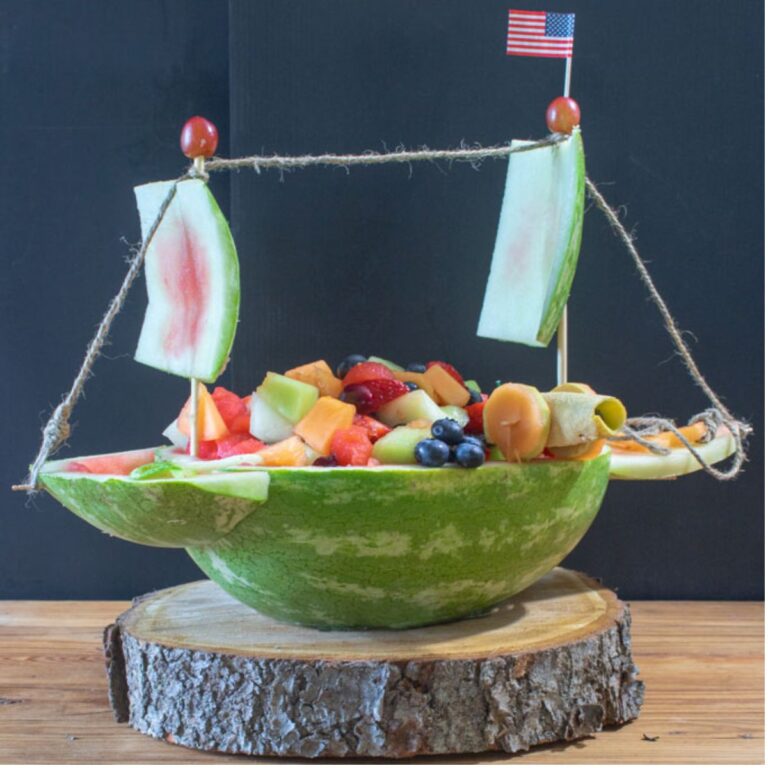 Fruit Salad presented in a ship shape carved from a watermelon.
