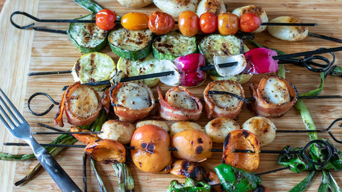 Skewered scallops and vegetables on a basket