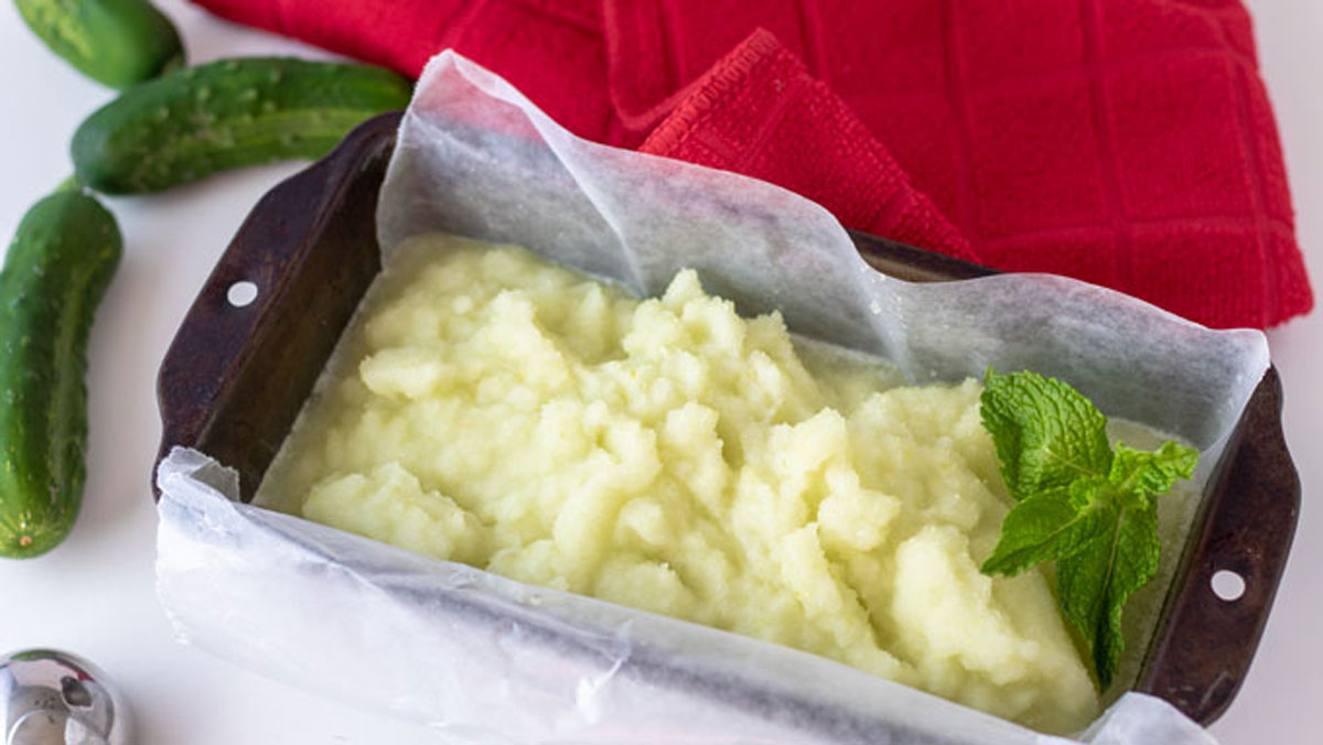 Bread pan filled with Cucumber sorbet that is garnished with mint leaves.