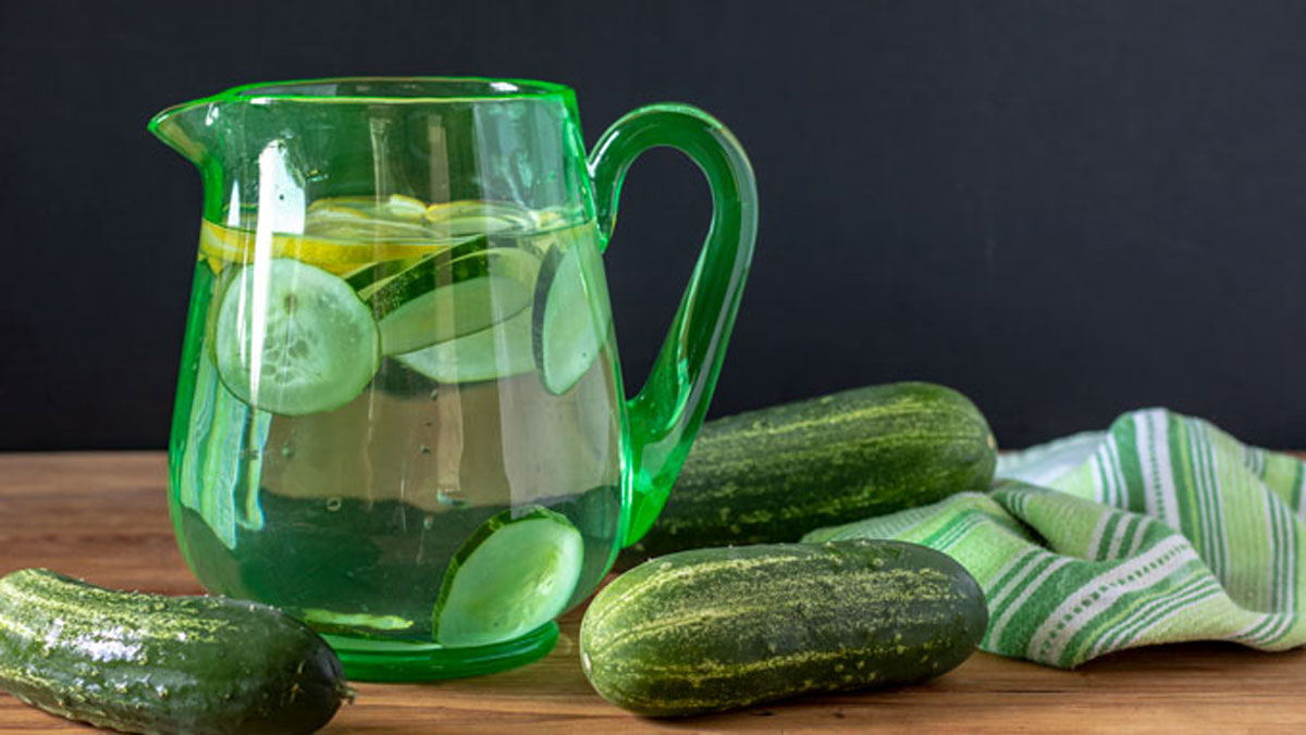 Green pitcher with cucumber lemon water.