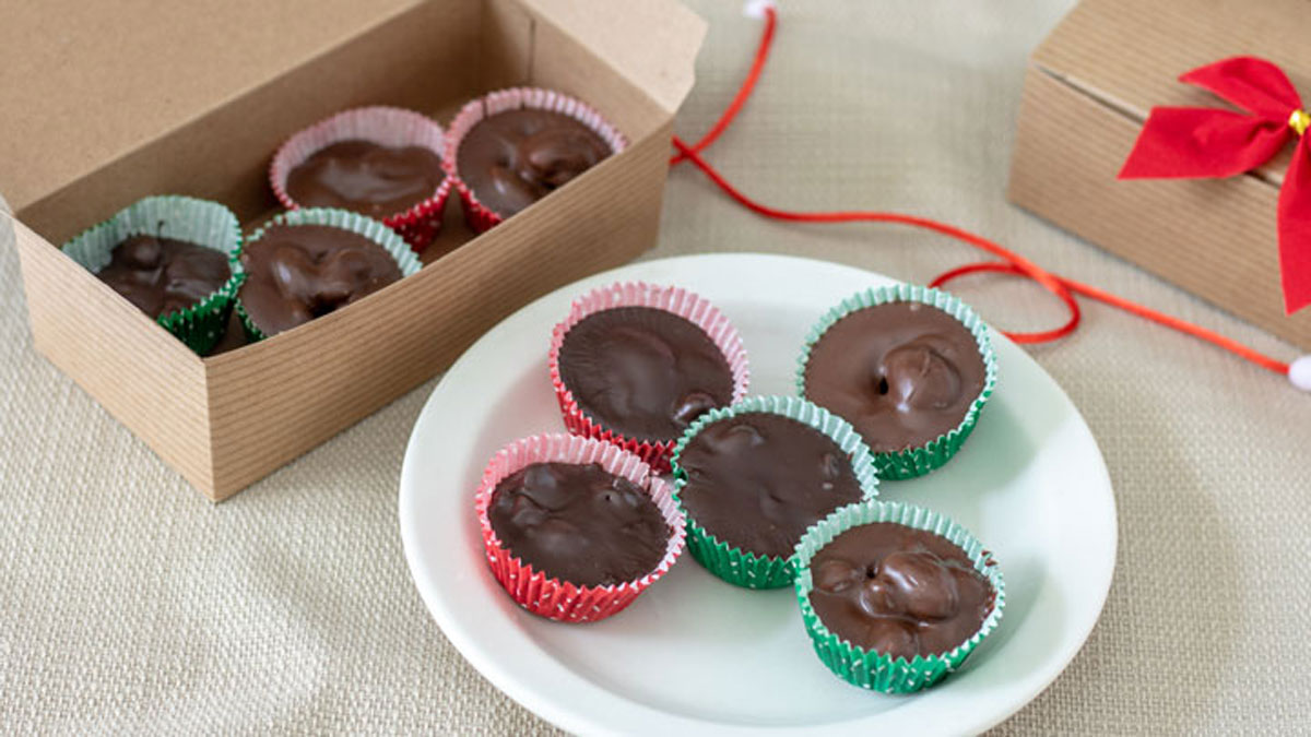 Chocolate covered nuts on white plate and in gift box.