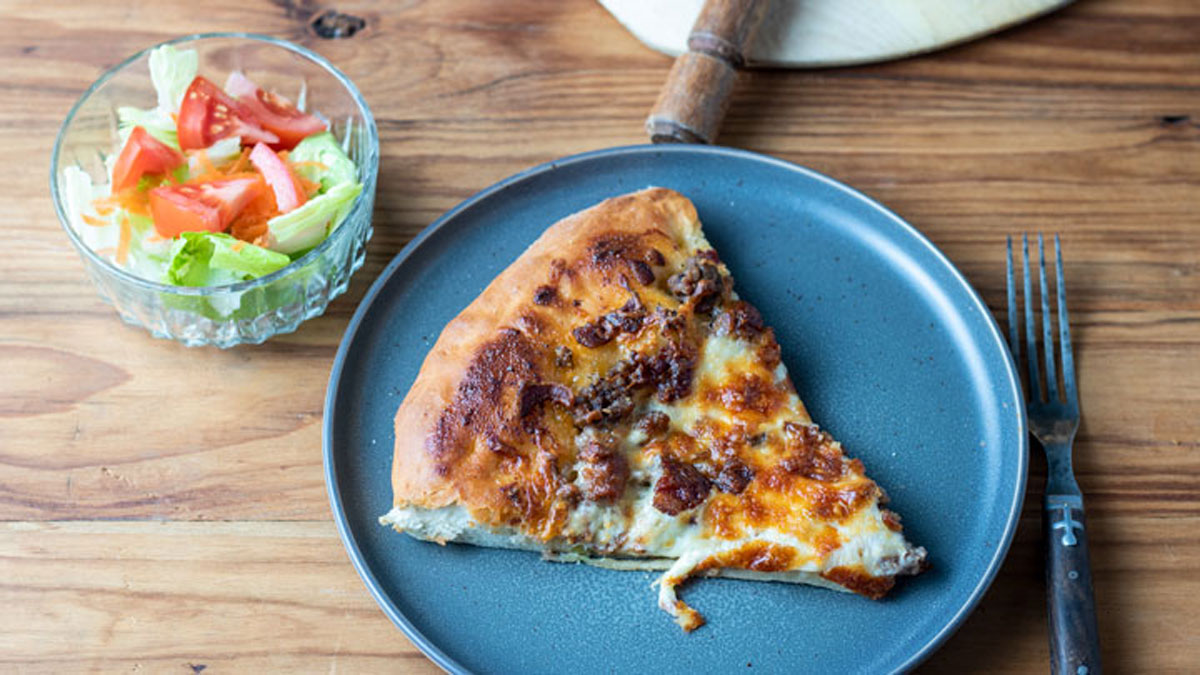 slice of pizza with side salad. Slice of pizza with side salad.