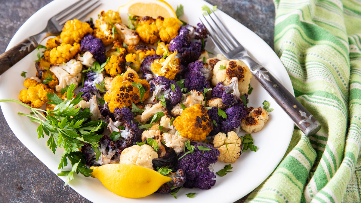 Colorful cauliflower in a white bowl.